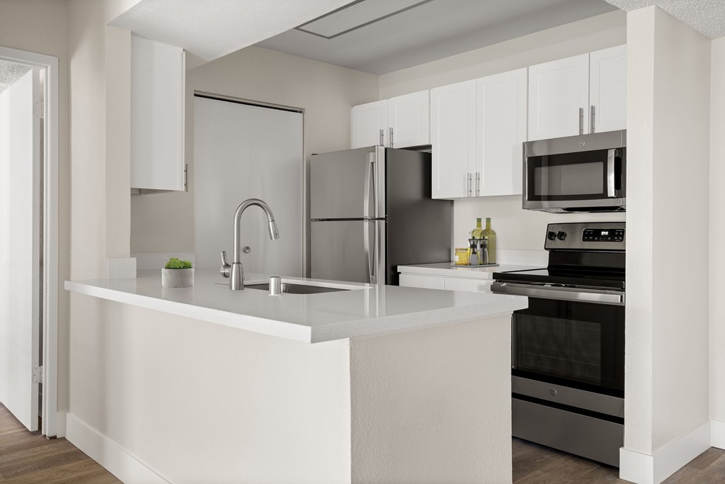 a kitchen with white cabinetry and stainless steel appliances